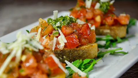 Mediterrane Bruschetta mit Rucolapesto und Grana Padano